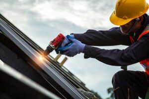 Homeowner reviews insurance papers while viewing storm-damaged shingles through a window.